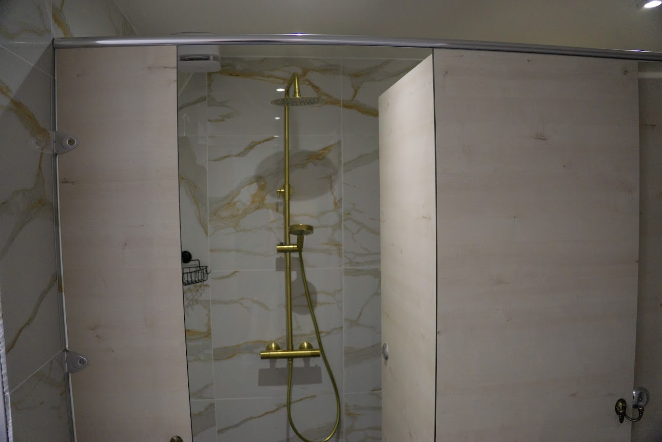 Marble-effect shower cubicle with gold fixtures